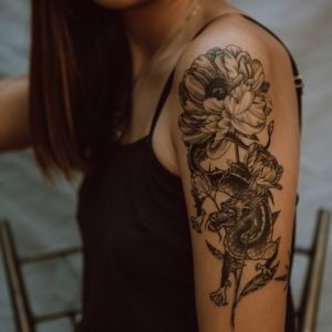 woman with black and brown floral tattoo on her back